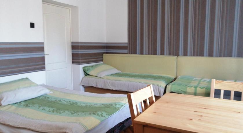 a bed room with two beds and a desk, Belvarosi Vendeghaz in Miskolc