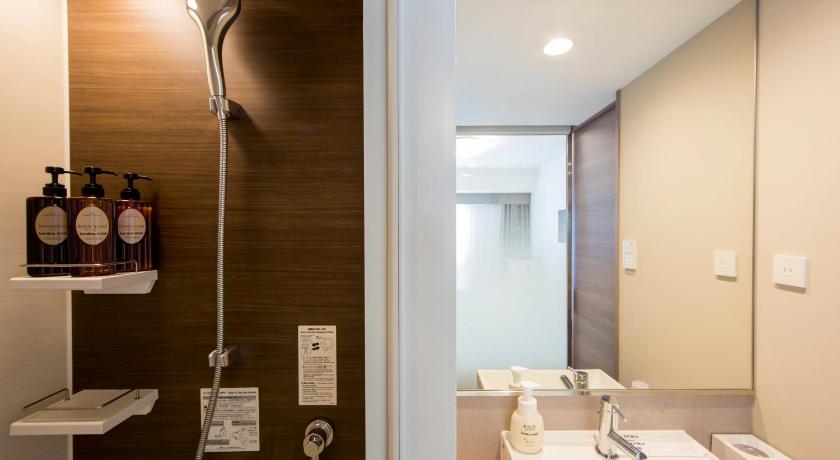 a bathroom with a sink, toilet and mirror, karaksa hotel Osaka Namba in Osaka
