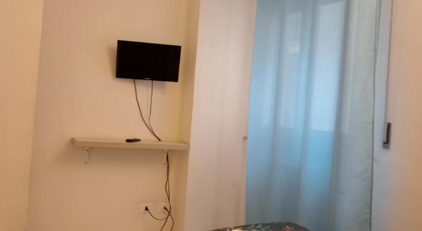 a small room with a bed and a television, Pisacentro Guest House in Pisa