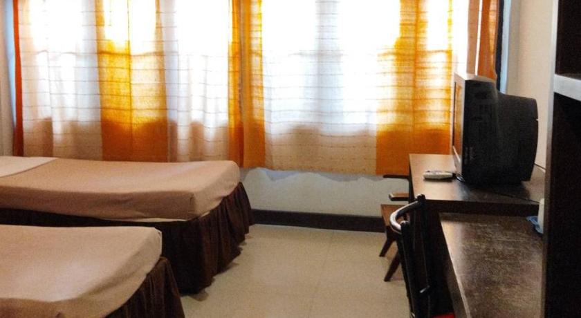 a hotel room with two beds and a television, ไทยโฮเต็ล in Buriram