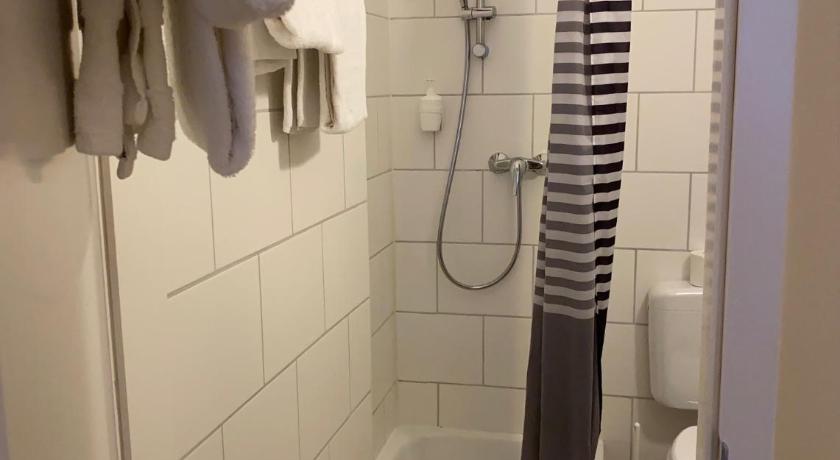 a bathroom with a shower stall and a towel rack, ALPHA Hotel Garni in Hamburg