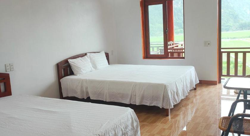 a hotel room with two beds and two windows, Tree House Resort Ninh Binh in Ninh Bình