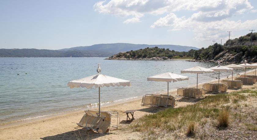 a beach with umbrellas on the sand, Agionissi Resort in Ammouliani