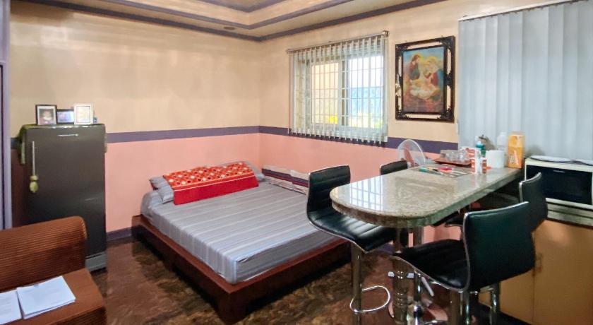 a hotel room with a bed, desk, and chairs, RedDoorz Hostel @ Arc Residences Baguio in Baguio