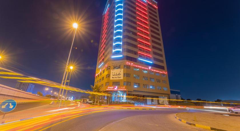 a city street at night with tall buildings, Ewan Ajman Suites Hotel in Ajman