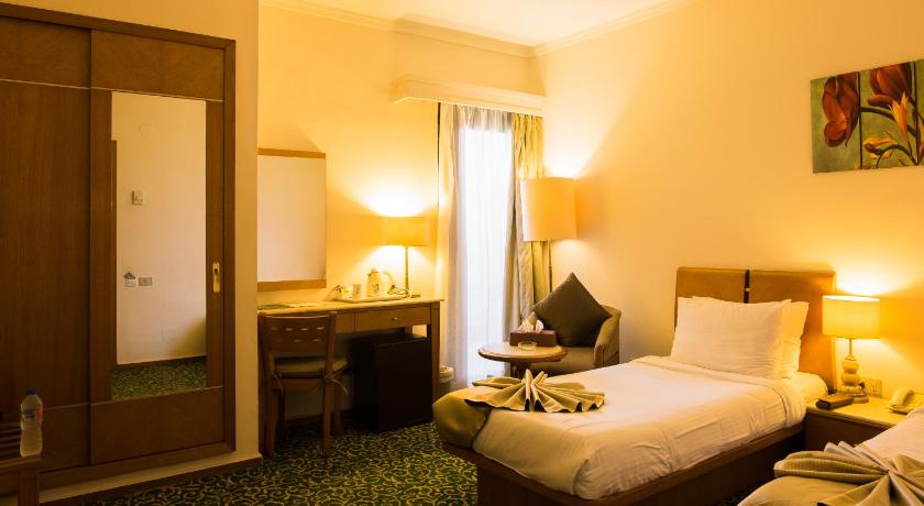a hotel room with two beds and a desk, Plaza Hotel Alexandria in Alexandria