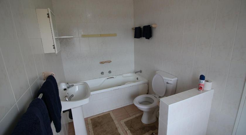 a white toilet sitting next to a sink in a bathroom, Clinch Self Catering in Durban