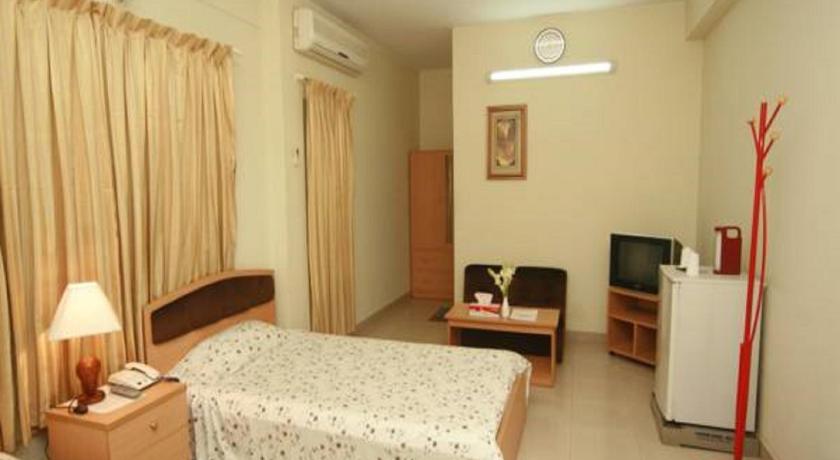 a bedroom with a bed and a television, Red Chillies Restaurant and Guest house in Bogra