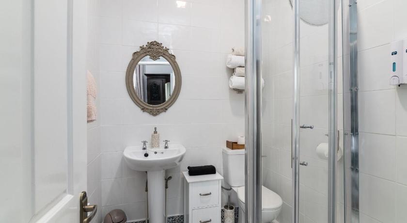 a bathroom with a shower, toilet, sink and mirror, Riverdale House B&B in Athlone