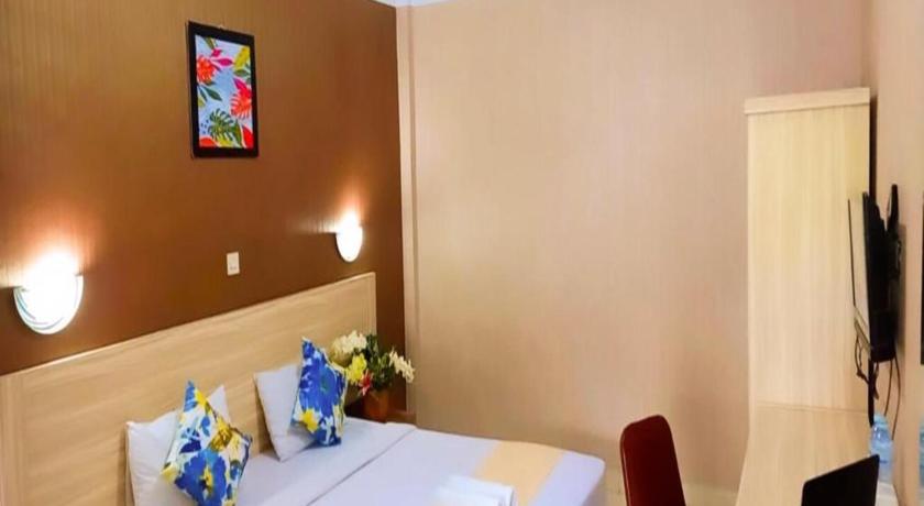 a hotel room with a white table and white walls, D'Lira Syariah Hotel in Pekanbaru