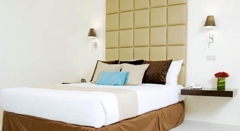 a hotel room with a white bed and white pillows, The Oracle Hotel & Residences in Manila