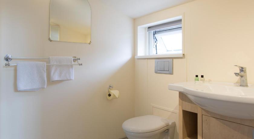a white toilet sitting next to a white sink, Oakwood Bed and Breakfast Heathrow in London