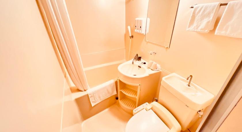 a white toilet sitting next to a sink in a bathroom, Reisenkaku Hotel Kawabata Nakasu in Fukuoka