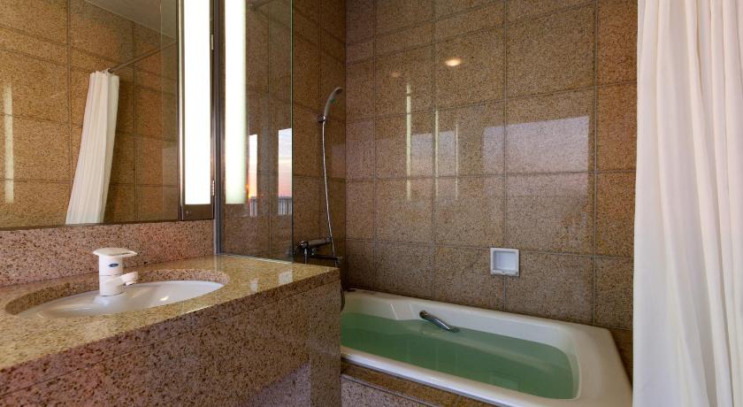 a bathroom with a tub, toilet and sink, Hotel Uohan in Karatsu