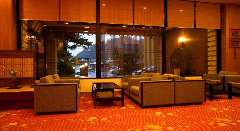a living room filled with furniture and a large window, Ryokan Sanrakuen in Takaoka