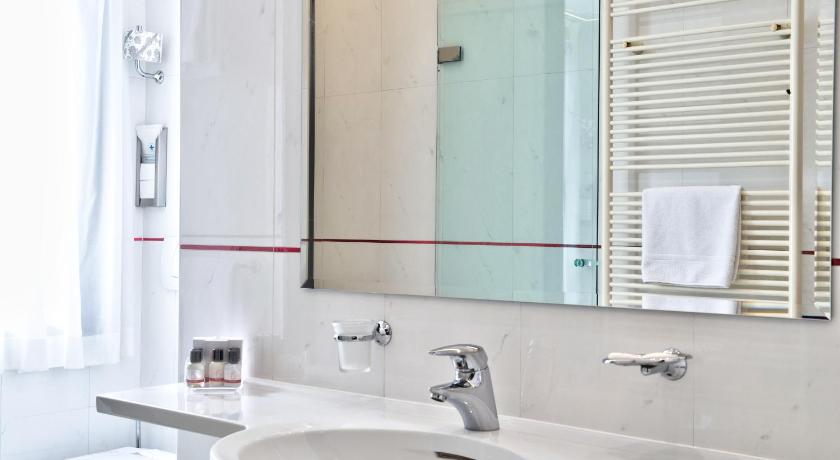 a bathroom with a sink and a mirror, Central Park Hotel in Modena