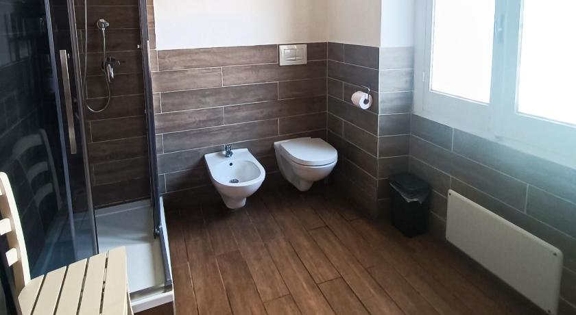 a bathroom with a toilet a sink and a window, Kalie Rooms Guest House in Cagliari