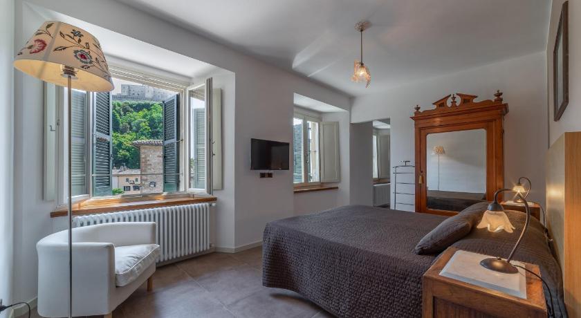 a hotel room with a bed, chair and a tv, San Leo Albergo Diffuso in San Leo