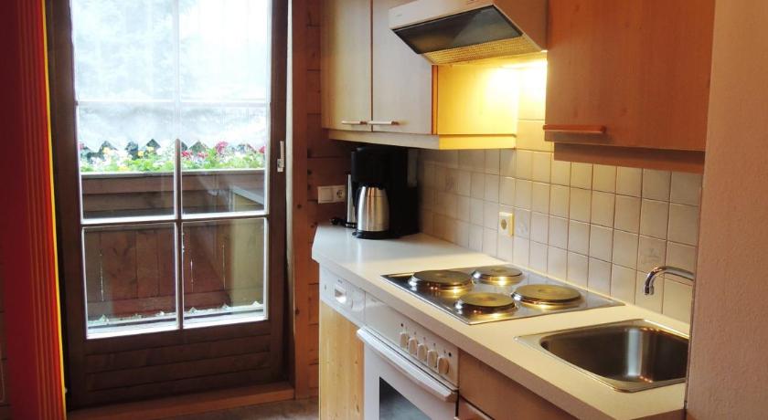 a kitchen with a stove a sink and a window, Haus Carina in Flachau