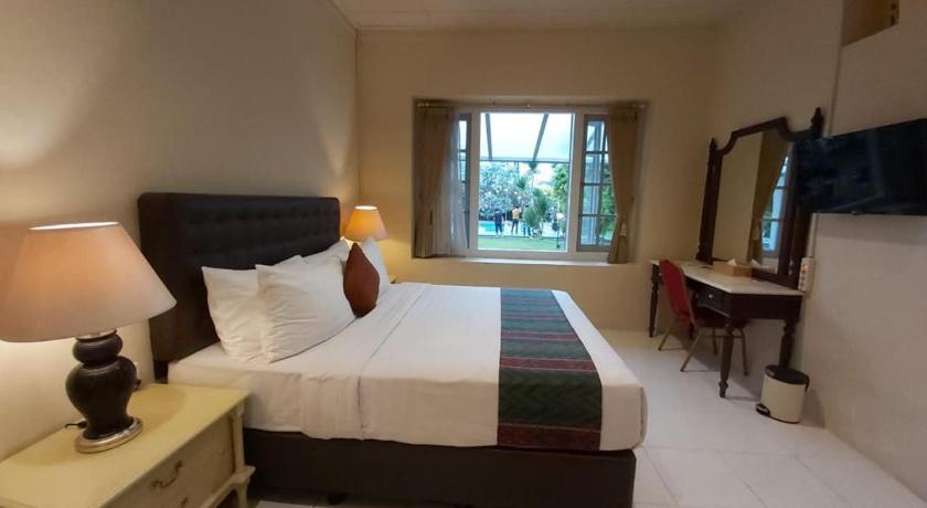 a hotel room with a bed and a desk, Hotel Indah Palace Tawangmangu in Tawangmangu