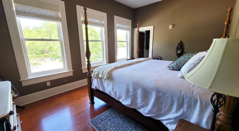 a bedroom with a large bed and a large window, Camellia Rose Inn- King Room Southern Charm in Gainesville (FL)