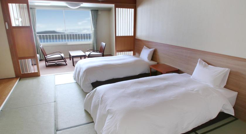 a hotel room with a bed, chair and a window, Hotel Gozensui in Kushiro