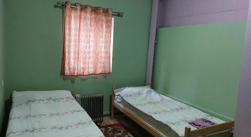 a bedroom with two beds and a window, KONOK Center OSH in Osh