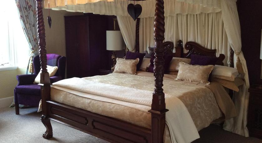 a large bed with a canopy on top of it, Glebe Country House Tarbet in Tarbet Argyll and Bute