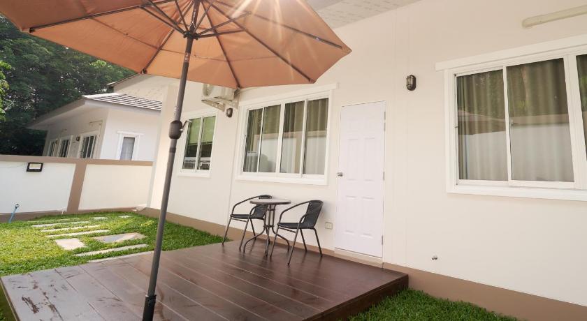 a white umbrella sitting on top of a wooden bench, Blue Cat Pool Villa 1 in Chanthaburi