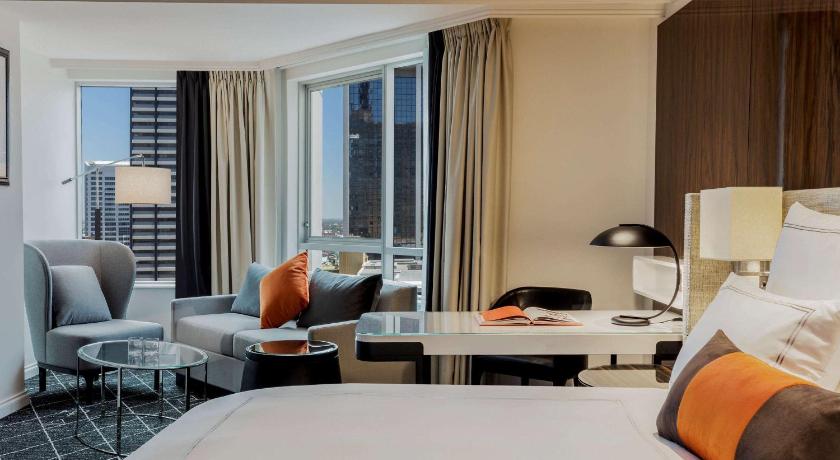 a hotel room with a couch, chair, and table, Swissôtel Sydney in Sydney