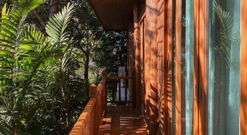 a walkway leading to a balcony overlooking a forest, Vanasin Residence in Tak