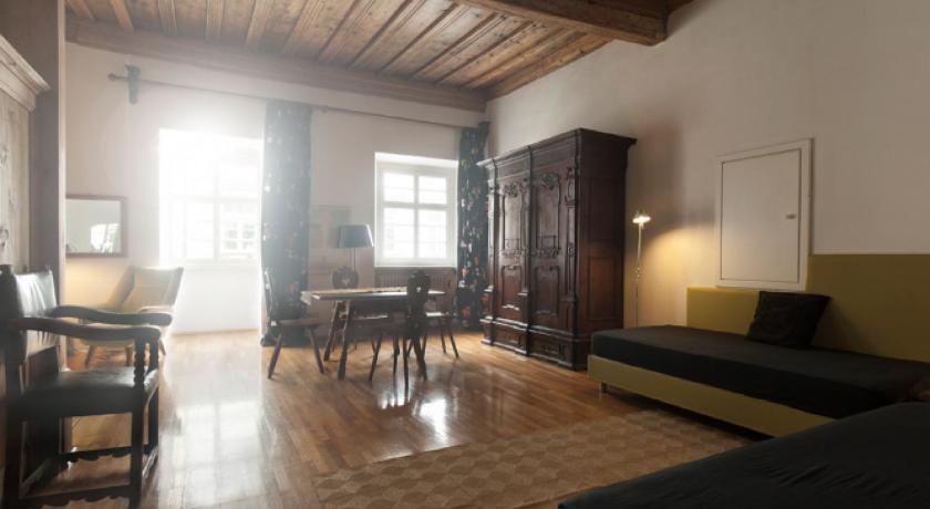 a living room filled with furniture and a large window, Residence Fink Central Apartments in Bolzano