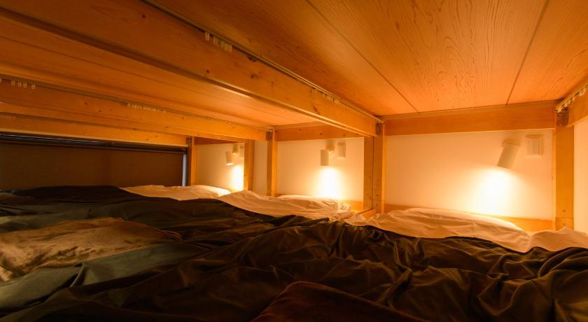 a bedroom with a bed and a lamp, Guesthouse Kintoto in Kanazawa