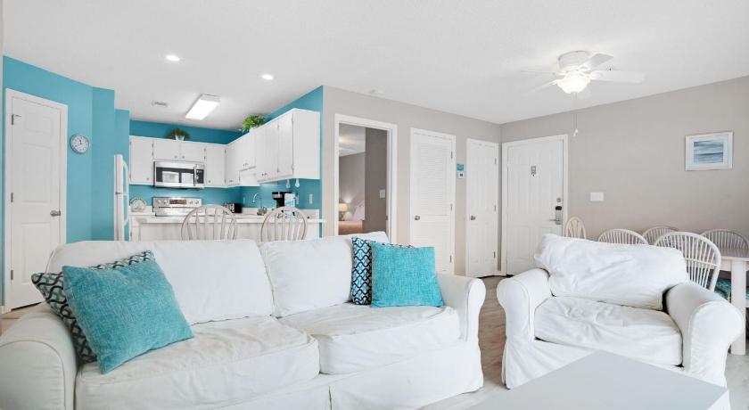 a living room filled with furniture and pillows, St. Martin Beachwalk Villas 122 by Real Joy in Destin (FL)