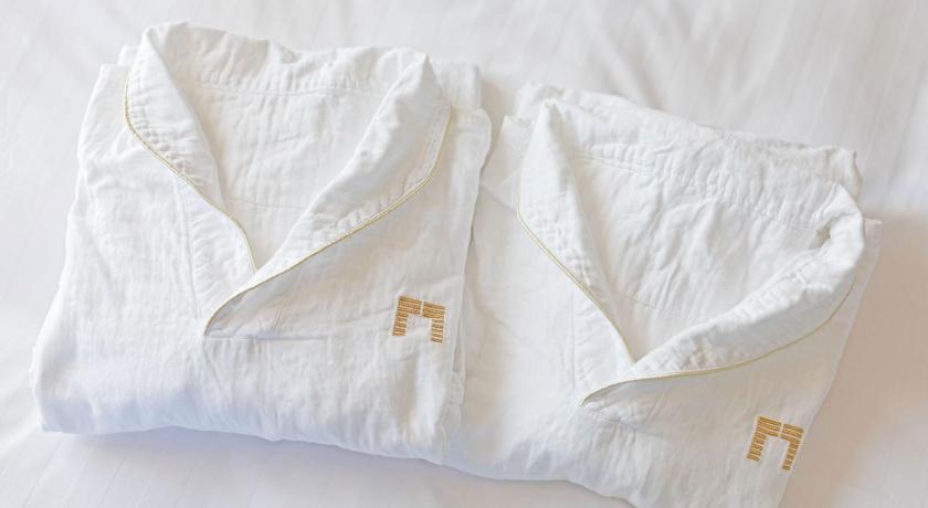 a white towel wrapped around a white pillow on top of a bed, THE GATE HOTEL RYOGOKU by HULIC in Tokyo