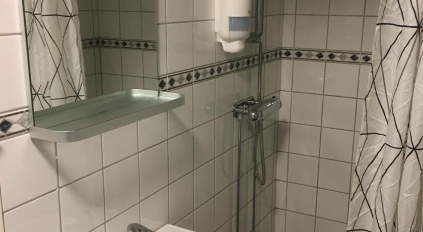 a bathroom with a sink, toilet, and bathtub, Hostel Snoozemore in Gothenburg