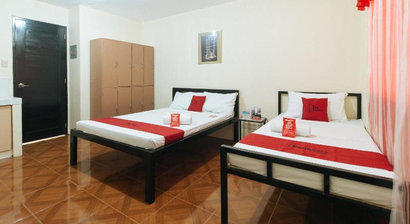 a hotel room with two beds and two lamps, RedDoorz @ FDB Homes Nueva Ecija in San Jose (Nueva Ecija)