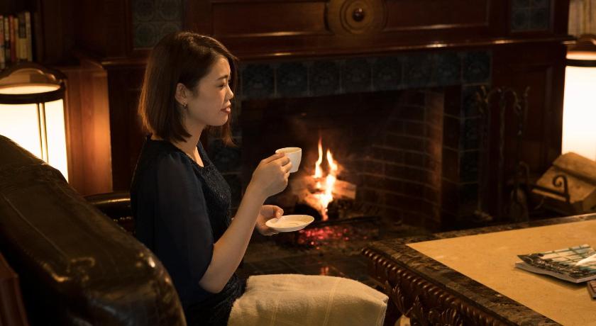 a woman is lighting candles on a fire place, The Hamilton Ureshino in Ureshino