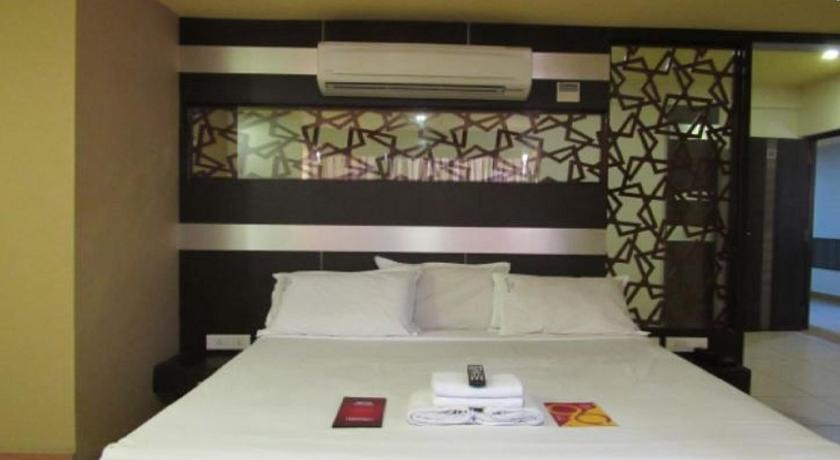 a bed with white sheets and pillows in a bedroom, Devis Grand Hotel in Pondicherry