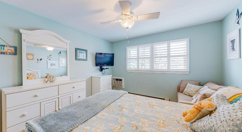 a bedroom with a bed, a dresser, and a window, Beachcrest 3 in Ocean City (MD)