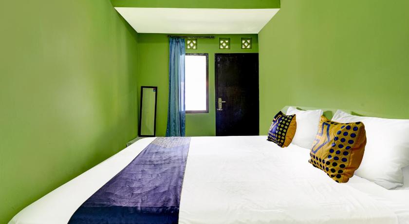 a bedroom with a blue and white bedspread and blue walls, SPOT ON 91116 Pelangi Residence Syariah in Bandung