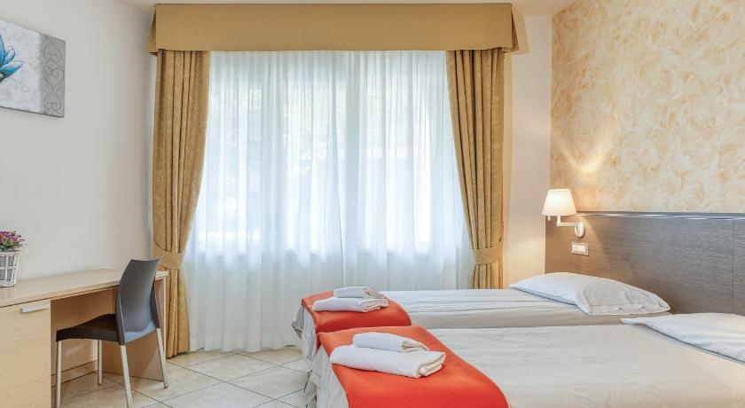 a hotel room with two beds and two lamps, Hotel Lumin in Cremia