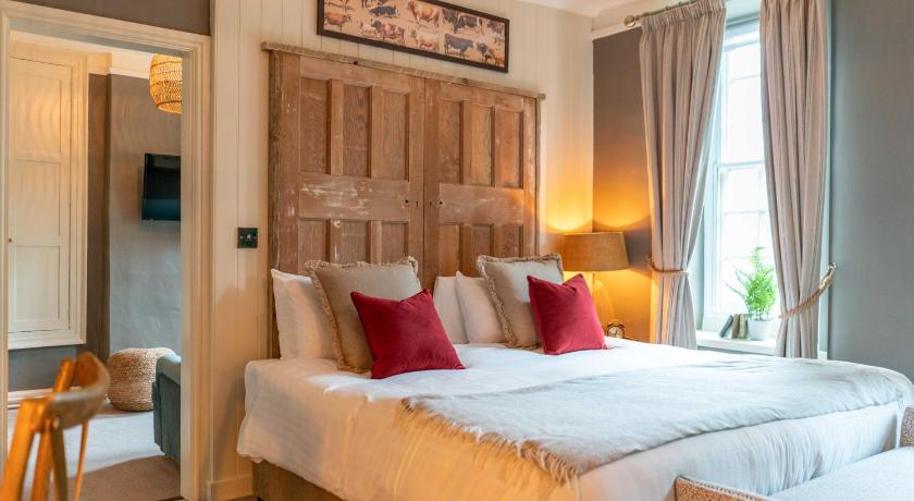 a hotel room with a large bed and a large window, The George Inn & Plaine in Bath