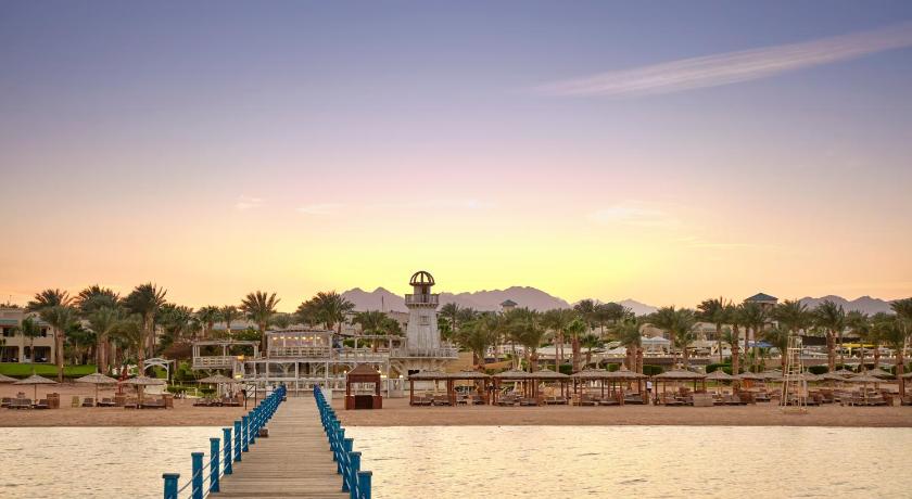 a pier with a row of benches next to the water, Coral Sea Holiday Resort and Aqua Park in Sharm El Sheikh