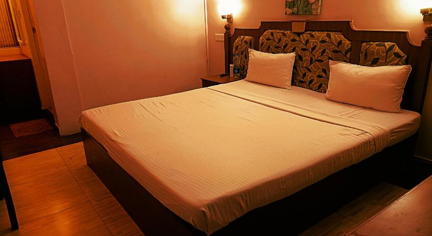 a hotel room with a bed and two lamps, Royal Residency in Kochi