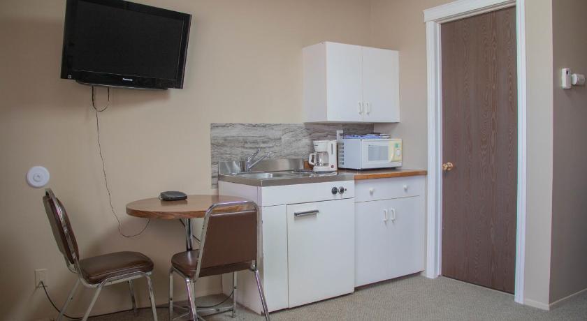 a kitchen with a refrigerator, microwave, sink, and dishwasher, Prairie Oasis Tourist Complex in Moose Jaw (SK)