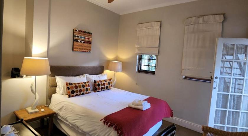 a bedroom with a bed and a lamp, Melville Turret Guesthouse in Johannesburg