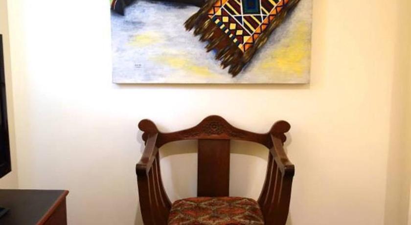 a room with a chair and a painting on the wall, The Big House - A Heritage Home in Davao City