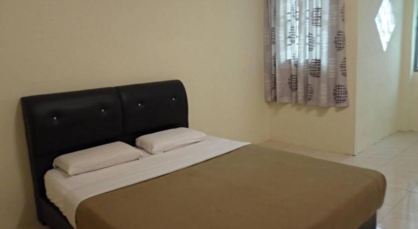 a bed in a room with a white bedspread, Super Budget 3 Rooms Apartment @ Brinchang Town in Cameron Highlands