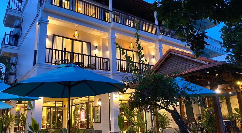 a hotel room with a balcony overlooking the ocean, The Quin Riverside Villa in Hoi An